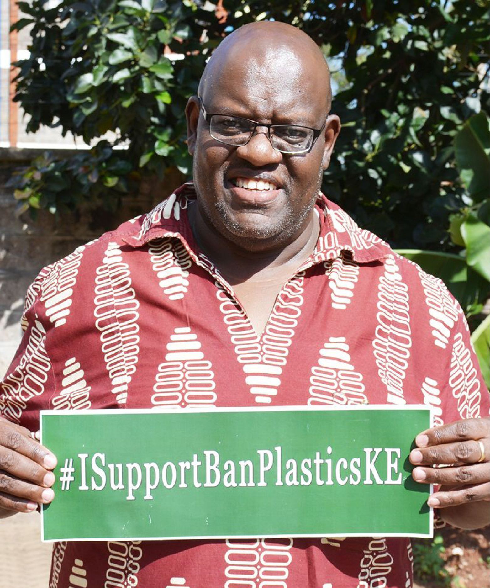 Person holding '#IsupportBanPlasticKE' banner